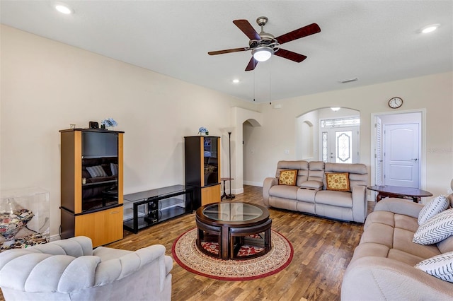 living room with ceiling fan and dark hardwood / wood-style flooring