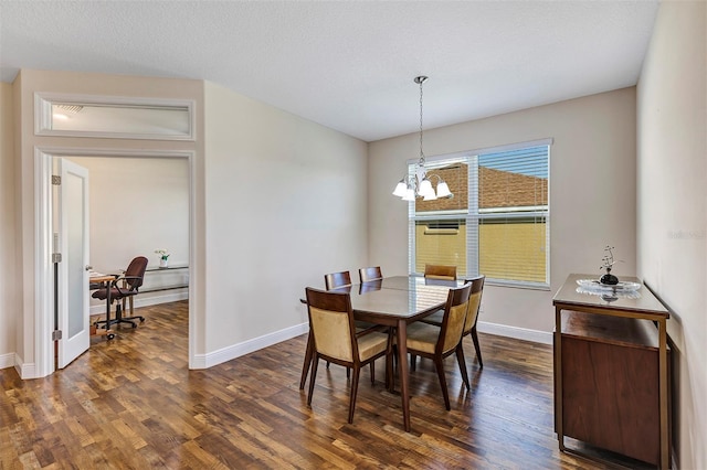 dining room featuring an inviting chandelier, a textured ceiling, and dark hardwood / wood-style floors