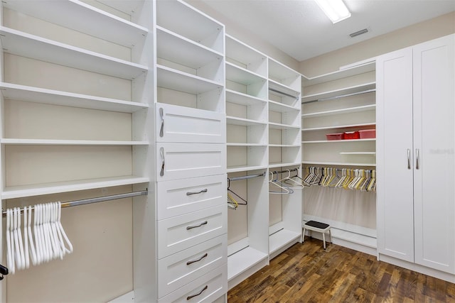 walk in closet with dark hardwood / wood-style floors