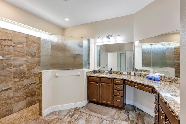 bathroom featuring a tile shower and vanity