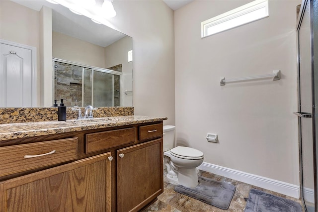 bathroom featuring vanity, toilet, and a shower with door