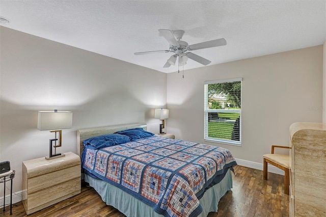 bedroom with ceiling fan, dark wood-type flooring, and a textured ceiling