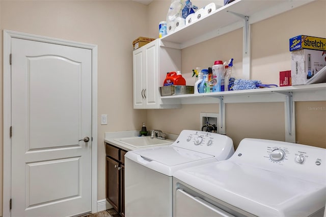 laundry area featuring sink, independent washer and dryer, and cabinets