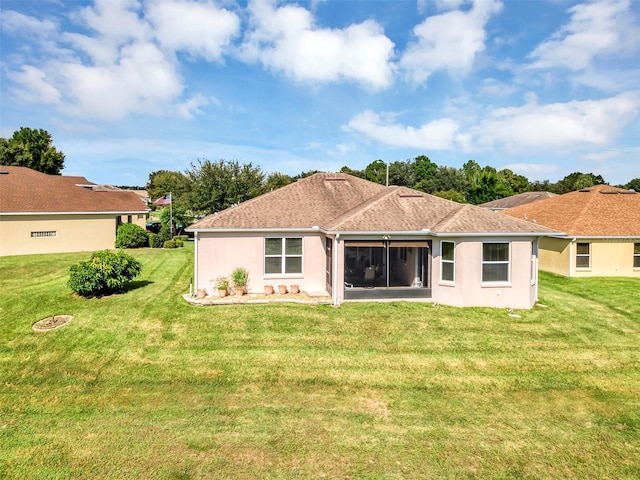 rear view of property with a lawn and a sunroom