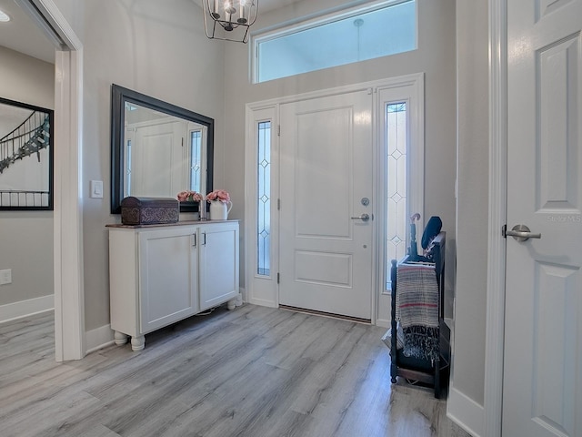 entryway with light hardwood / wood-style flooring and a notable chandelier