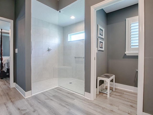 bathroom with tiled shower, a textured ceiling, and hardwood / wood-style flooring