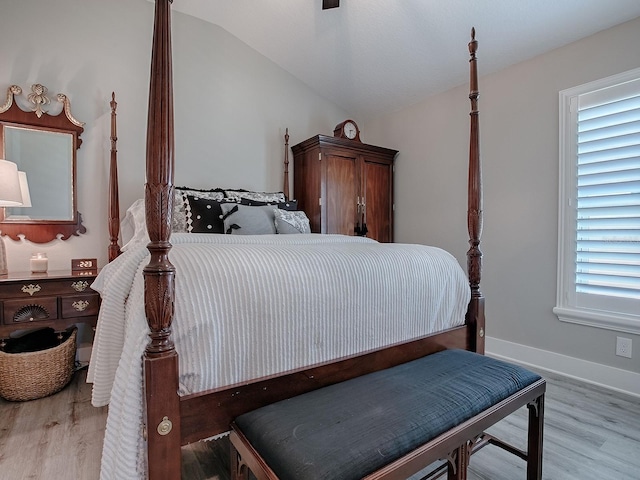 bedroom featuring vaulted ceiling and light wood-type flooring