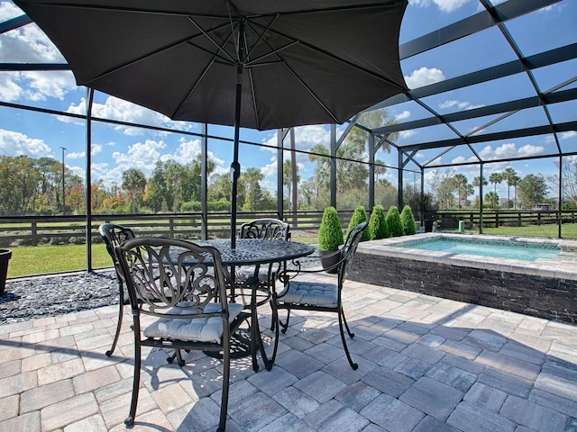 view of patio featuring glass enclosure and an in ground hot tub