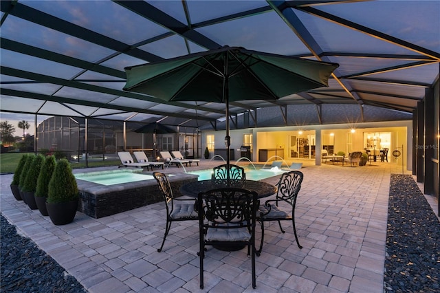 patio terrace at dusk with pool water feature, a pool with hot tub, and glass enclosure