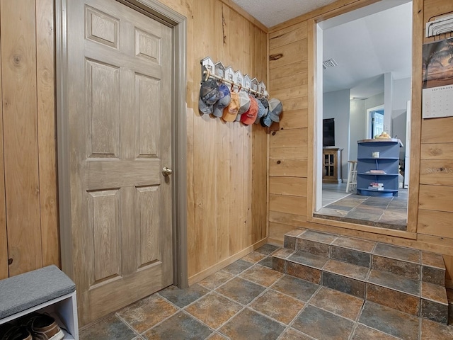 mudroom featuring wooden walls