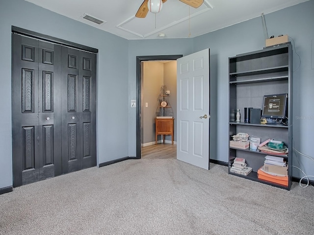 carpeted bedroom with ceiling fan and a closet