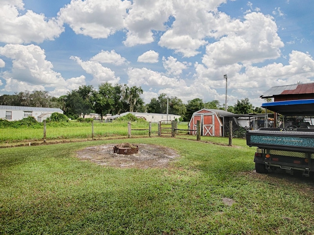 view of yard with a storage unit and an outdoor fire pit