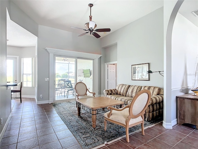 living room with dark tile patterned flooring and ceiling fan