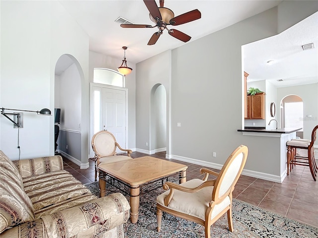 living room featuring dark tile patterned flooring, ceiling fan, and sink