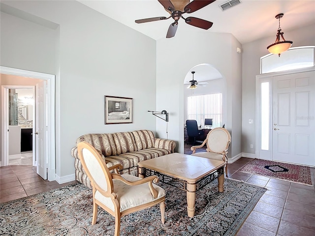 living room with ceiling fan, high vaulted ceiling, and dark tile patterned flooring