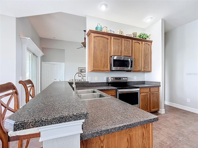 kitchen featuring ceiling fan, sink, stainless steel appliances, kitchen peninsula, and light tile patterned floors