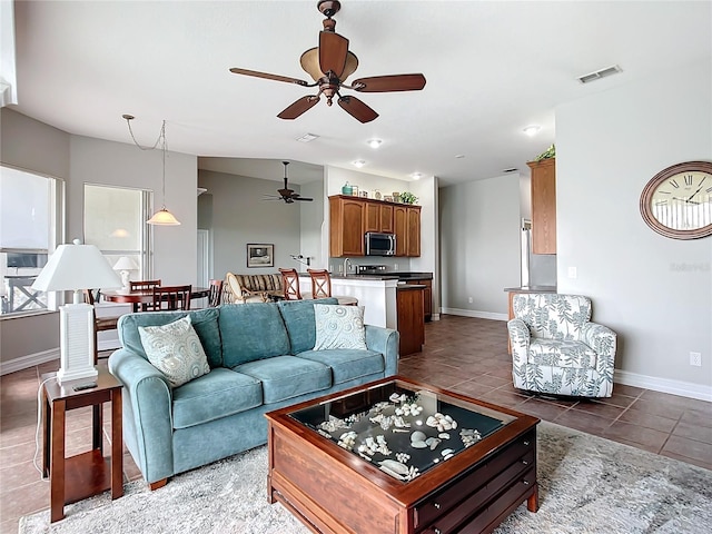 tiled living room featuring ceiling fan