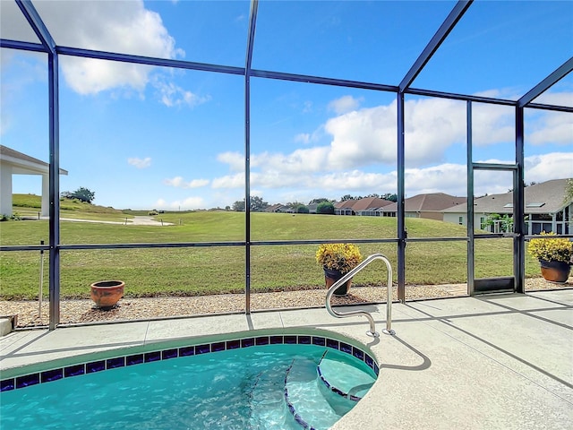 view of swimming pool featuring glass enclosure, a patio area, and a yard