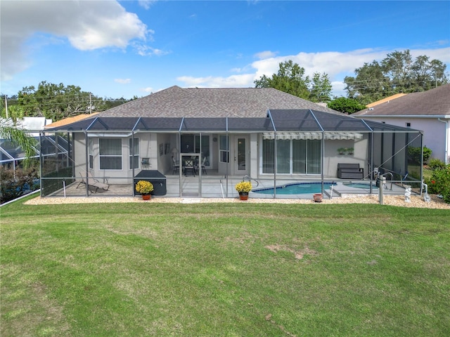 rear view of property featuring a lawn, a lanai, and a patio