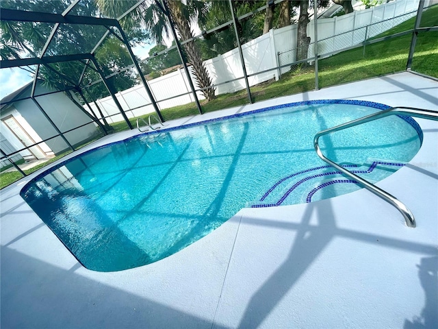 view of pool featuring a yard, a patio area, and a lanai