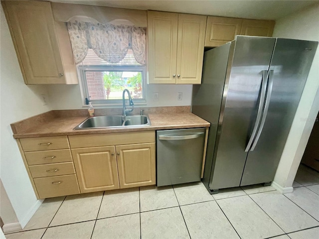 kitchen with light tile patterned floors, appliances with stainless steel finishes, sink, and light brown cabinets