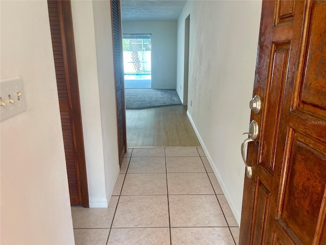 hallway with light tile patterned floors and a textured ceiling