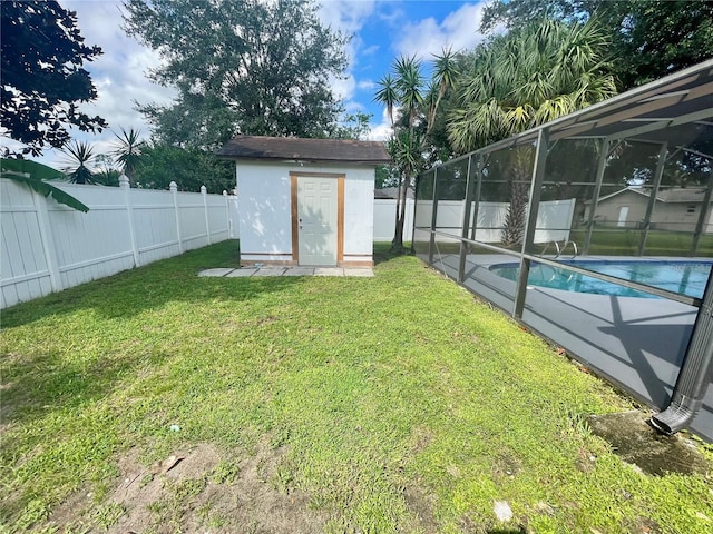 view of yard featuring a fenced in pool, a storage shed, and glass enclosure