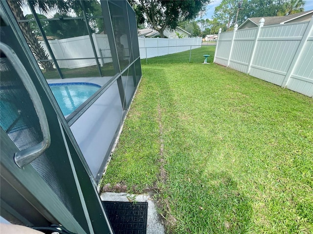 view of yard with glass enclosure and a fenced in pool