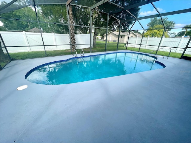 view of swimming pool with a patio area, glass enclosure, and a lawn