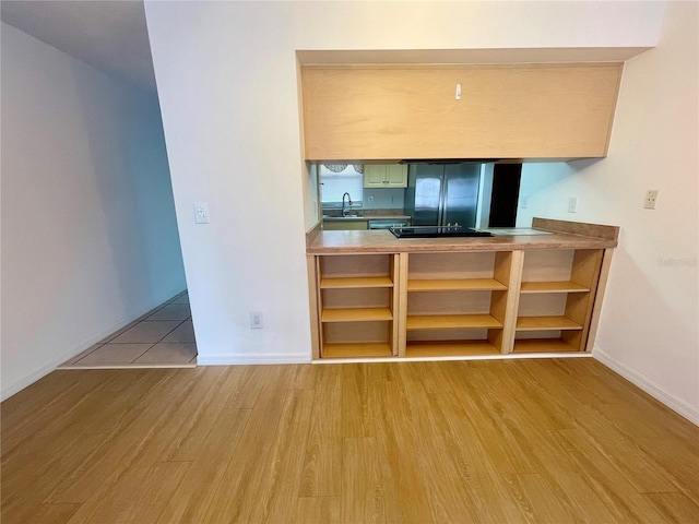 1415 Harnden Rd W, Port Orange, FL 32129 - kitchen featuring open shelves, wood finished floors, fridge, baseboards, and a sink