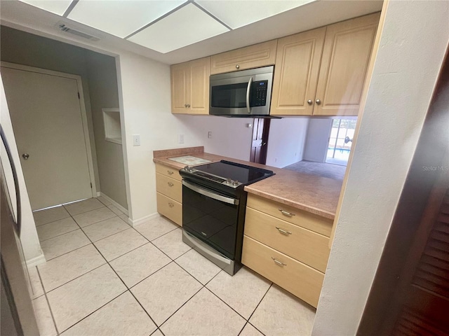 1415 Harnden Rd W, Port Orange, FL 32129 - kitchen featuring visible vents, light tile patterned floors, stainless steel microwave, electric stove, and light brown cabinets