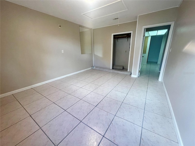 1415 Harnden Rd W, Port Orange, FL 32129 - unfurnished bedroom with light tile patterned floors, baseboards, attic access, and a closet