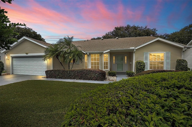 single story home featuring a garage and a lawn