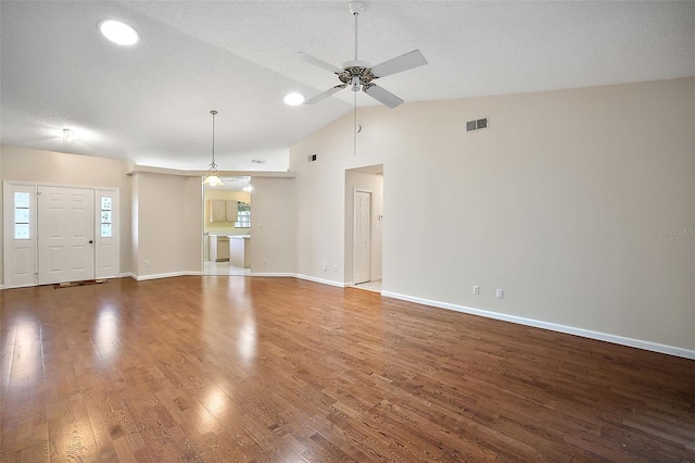 unfurnished living room featuring wood-type flooring, lofted ceiling, ceiling fan, and a textured ceiling