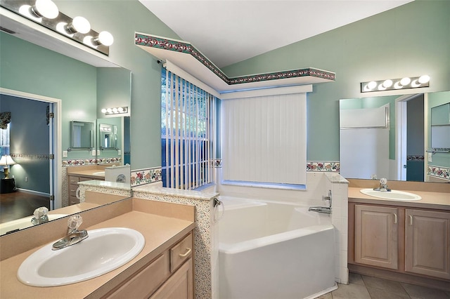 bathroom featuring lofted ceiling, tile patterned flooring, vanity, and a washtub