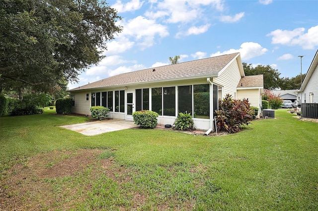 back of house featuring a lawn, a sunroom, and a patio area