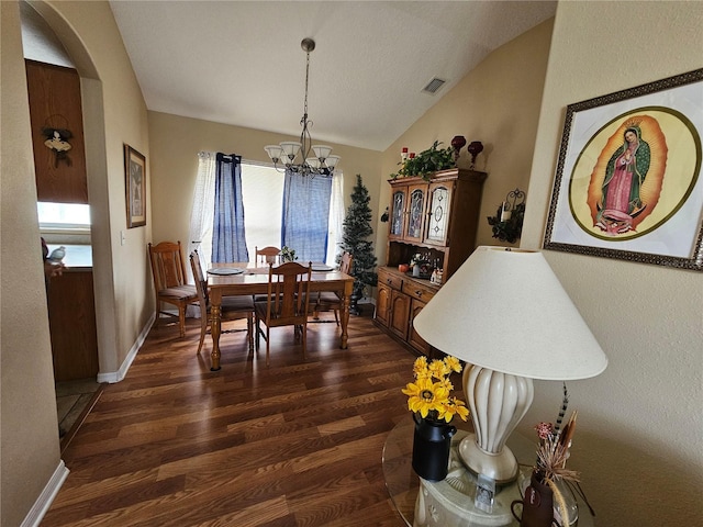 dining room featuring an inviting chandelier, vaulted ceiling, and dark hardwood / wood-style flooring