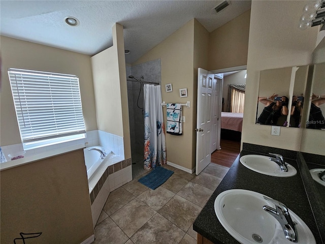 bathroom featuring vanity, a textured ceiling, lofted ceiling, plus walk in shower, and tile patterned floors