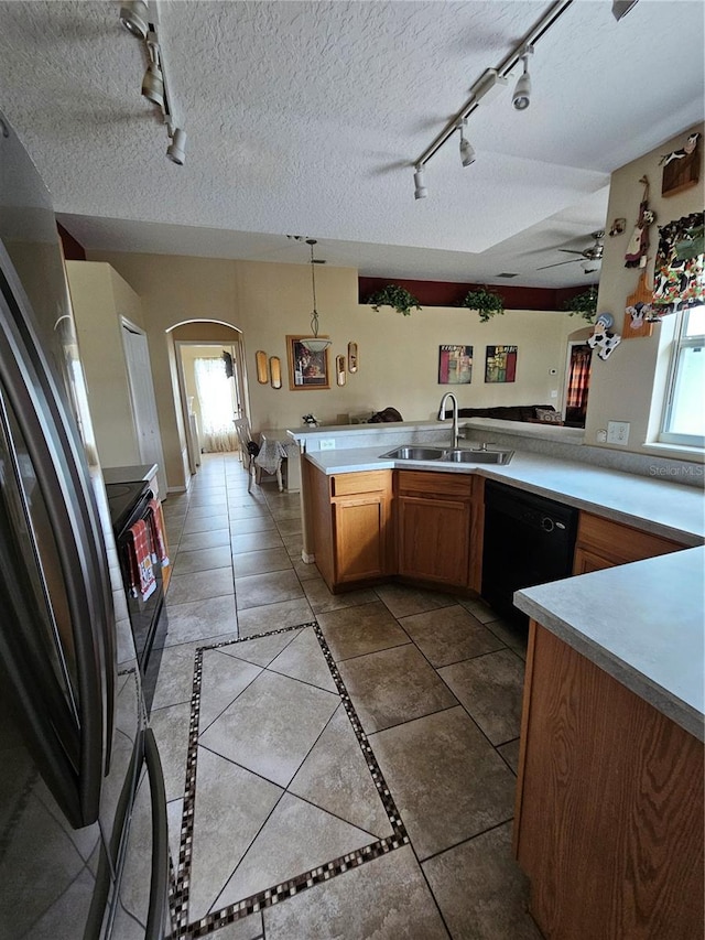 kitchen featuring pendant lighting, track lighting, sink, kitchen peninsula, and black appliances