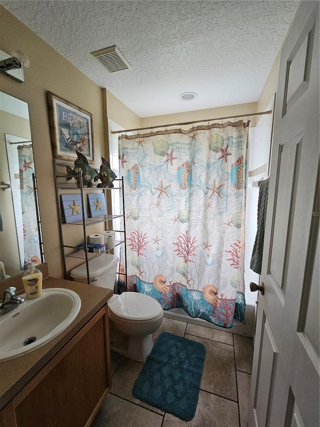 bathroom with tile patterned floors, a textured ceiling, vanity, and toilet