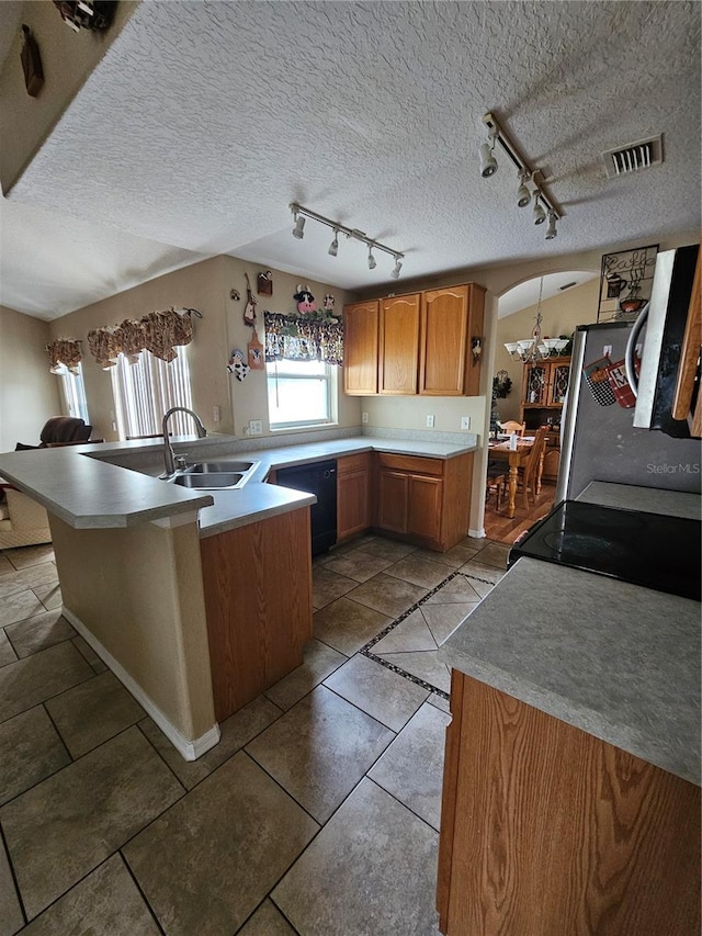 kitchen featuring black appliances, a textured ceiling, track lighting, and sink