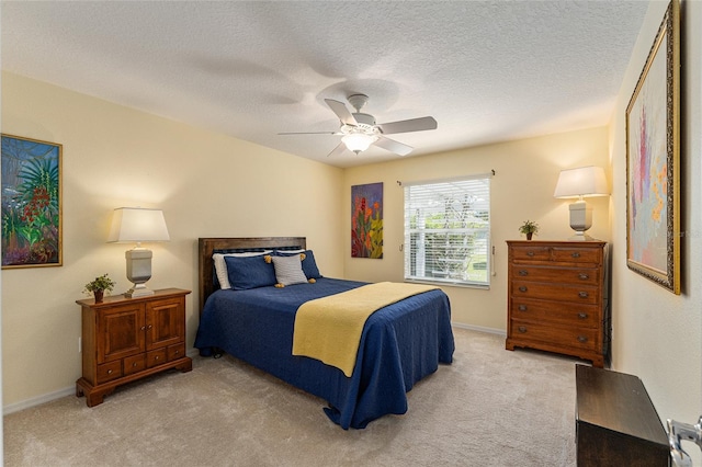 carpeted bedroom featuring ceiling fan and a textured ceiling