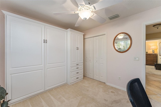 unfurnished office featuring light carpet and ceiling fan