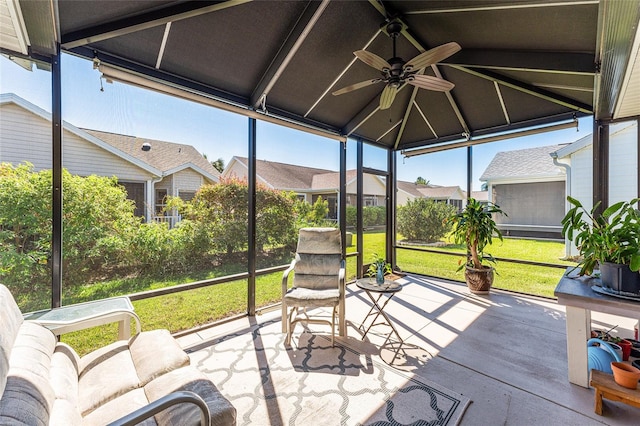 sunroom / solarium with ceiling fan, vaulted ceiling, and a wealth of natural light