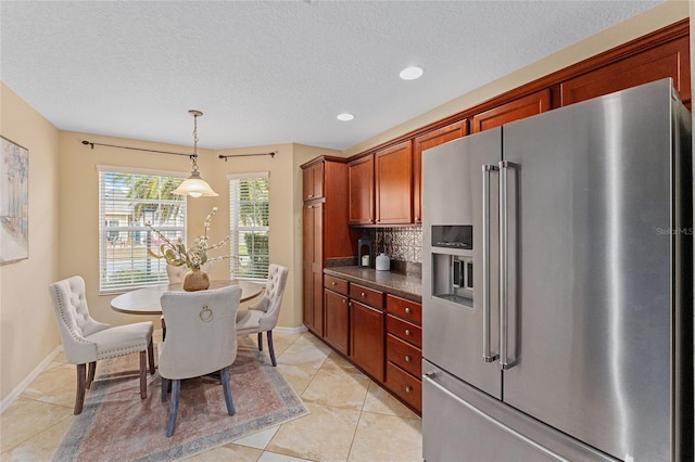 kitchen with decorative light fixtures, backsplash, high end refrigerator, a textured ceiling, and light tile patterned floors