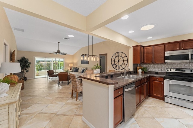 kitchen featuring lofted ceiling, kitchen peninsula, sink, and stainless steel appliances