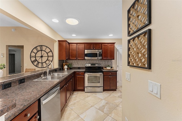 kitchen featuring stainless steel appliances, dark stone counters, tasteful backsplash, sink, and light tile patterned floors