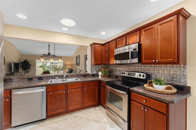 kitchen featuring appliances with stainless steel finishes, decorative backsplash, sink, hanging light fixtures, and light tile patterned floors