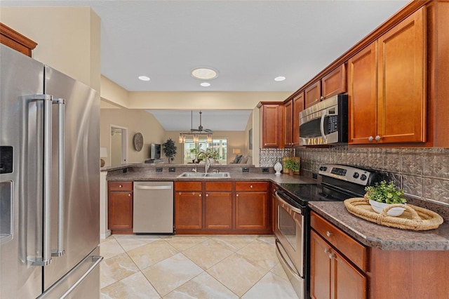 kitchen with sink, pendant lighting, appliances with stainless steel finishes, and tasteful backsplash