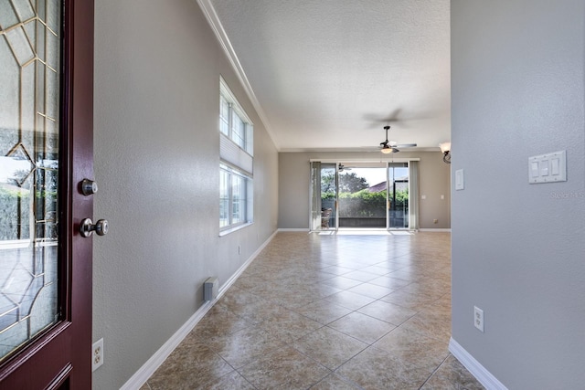 entrance foyer featuring ceiling fan, ornamental molding, and light tile patterned floors